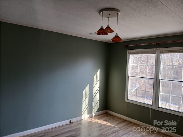 unfurnished room featuring a textured ceiling, a wealth of natural light, and wood-type flooring