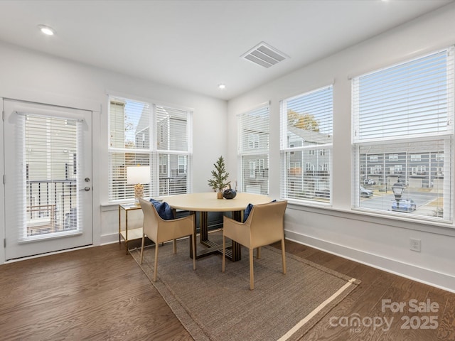 dining room with plenty of natural light and dark hardwood / wood-style flooring