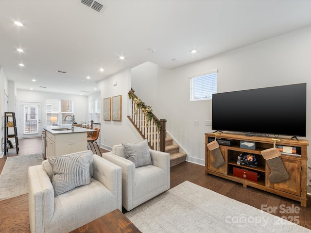 living room with hardwood / wood-style floors, sink, and a healthy amount of sunlight