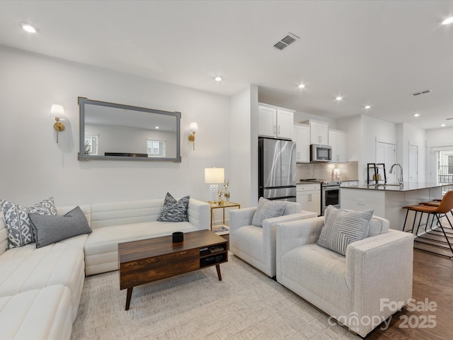 living room featuring light hardwood / wood-style floors and sink