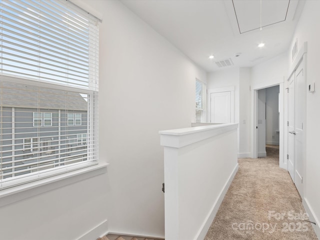 hallway featuring light colored carpet