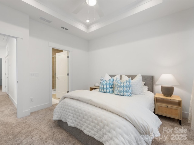 carpeted bedroom featuring ceiling fan, a raised ceiling, and connected bathroom