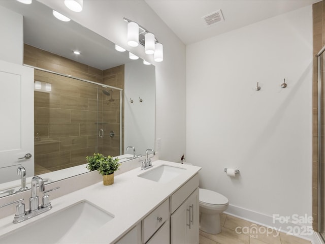 bathroom with tile patterned flooring, vanity, toilet, and walk in shower