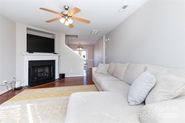 living room with ceiling fan and dark hardwood / wood-style flooring