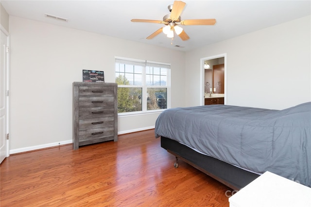 bedroom with ceiling fan, wood-type flooring, and ensuite bath