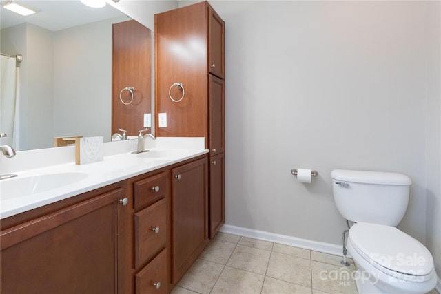 bathroom with toilet, vanity, and tile patterned floors