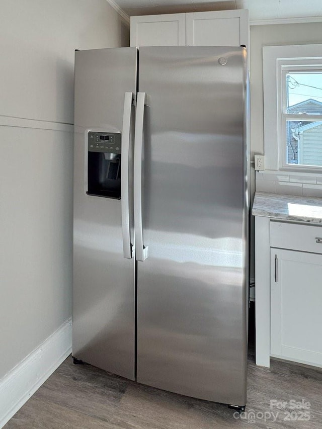 kitchen featuring crown molding, white cabinets, hardwood / wood-style flooring, and stainless steel refrigerator with ice dispenser