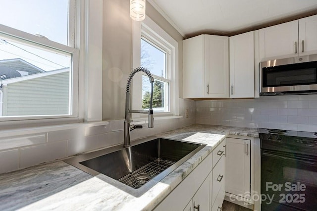 kitchen featuring sink, oven, white cabinets, and tasteful backsplash