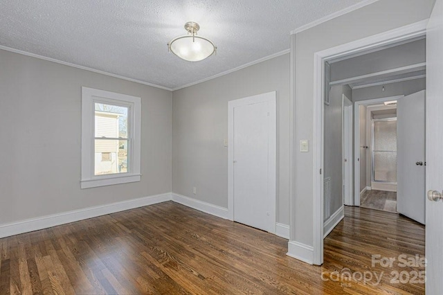 unfurnished room with dark hardwood / wood-style flooring, a textured ceiling, and ornamental molding