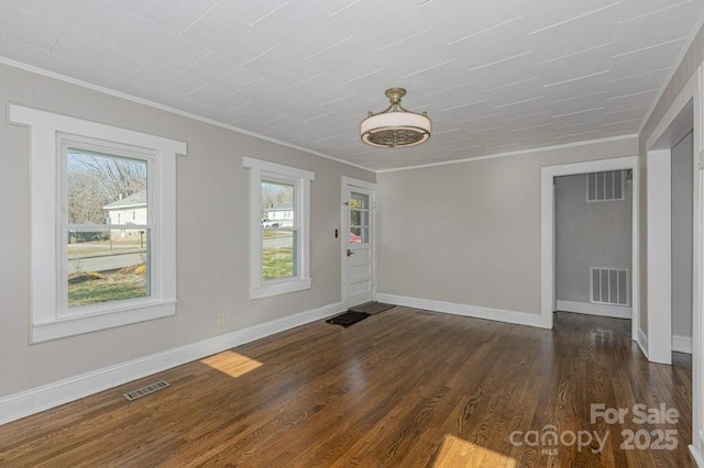 spare room featuring ornamental molding and dark hardwood / wood-style flooring