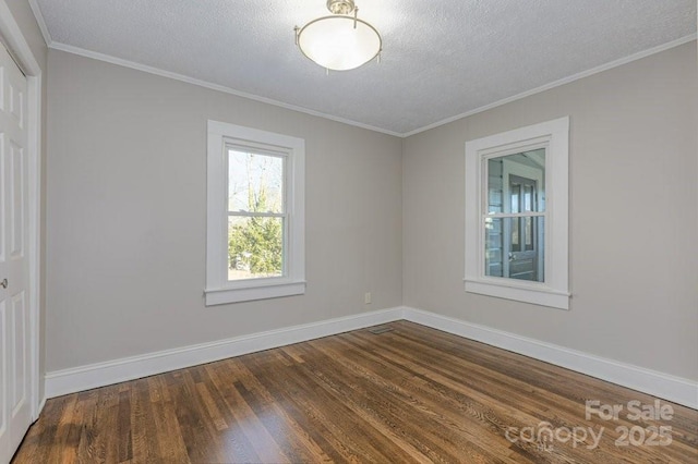 empty room featuring a textured ceiling, hardwood / wood-style floors, and crown molding