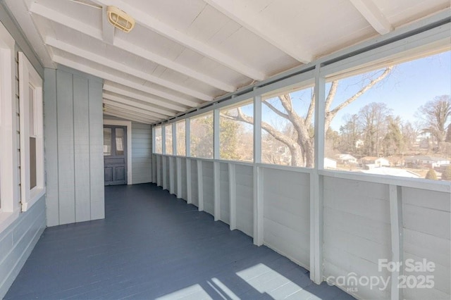 unfurnished sunroom featuring lofted ceiling and plenty of natural light