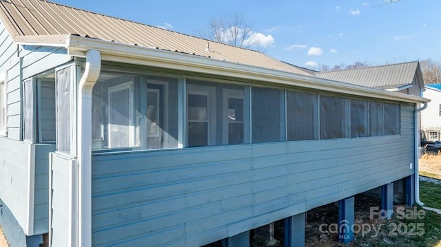 view of property exterior with a sunroom