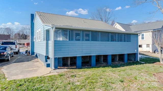 back of property featuring a yard and a sunroom