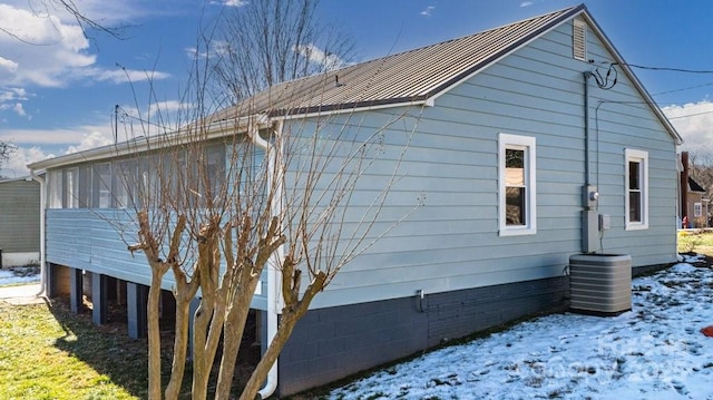 view of snow covered exterior featuring central AC