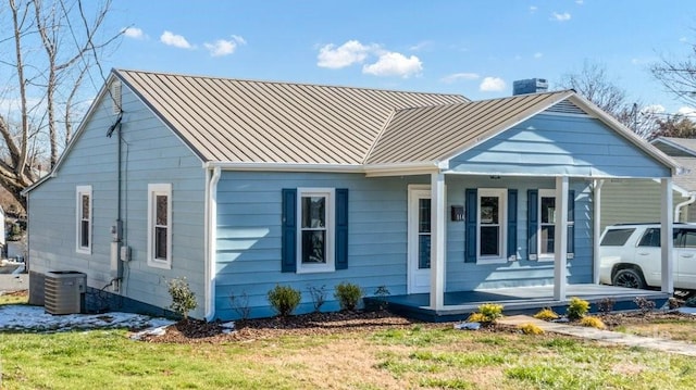 bungalow-style house with covered porch, a front lawn, and cooling unit