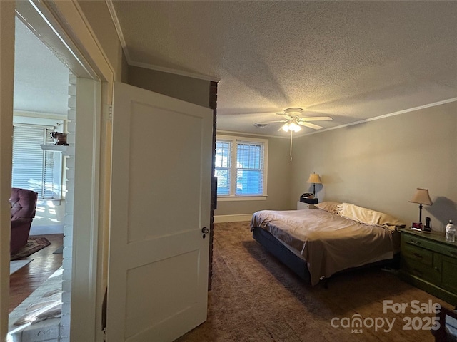 bedroom with ceiling fan, ornamental molding, dark carpet, and a textured ceiling