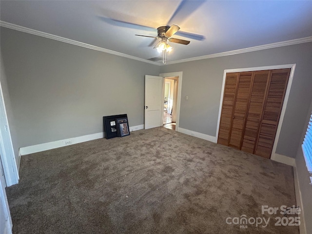 unfurnished bedroom featuring carpet, a closet, crown molding, and baseboards