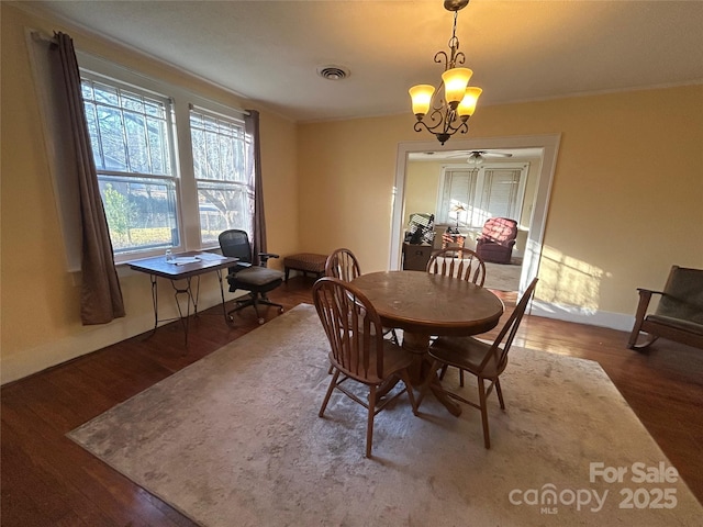 dining space featuring baseboards, visible vents, a chandelier, and dark wood-type flooring