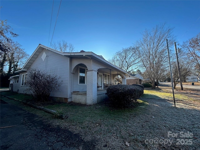 view of home's exterior with covered porch and crawl space