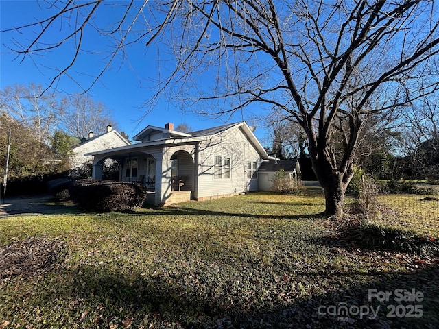 view of property exterior with a chimney, a porch, and a lawn