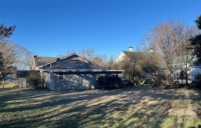 view of side of property with driveway and a yard