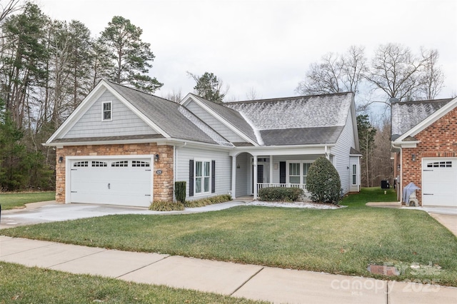 view of front of home featuring a garage, covered porch, and a front lawn