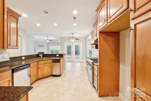 kitchen with sink, dark stone counters, french doors, and appliances with stainless steel finishes