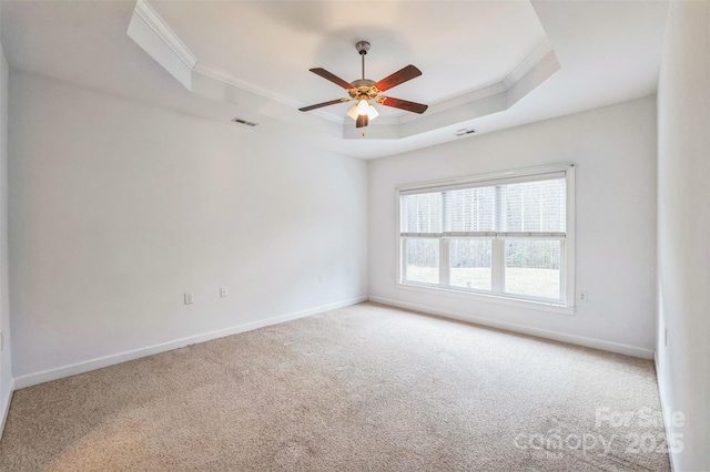 unfurnished room featuring ceiling fan, a raised ceiling, ornamental molding, and carpet floors