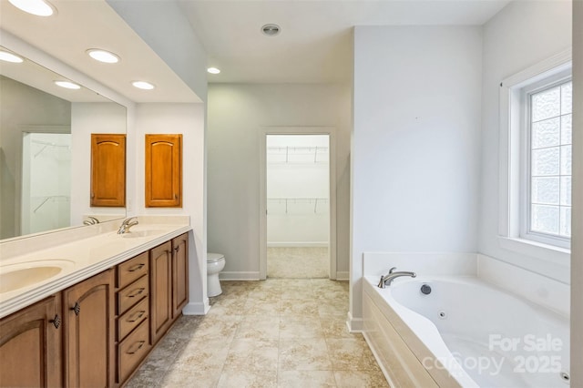 bathroom with vanity, toilet, a wealth of natural light, and a tub