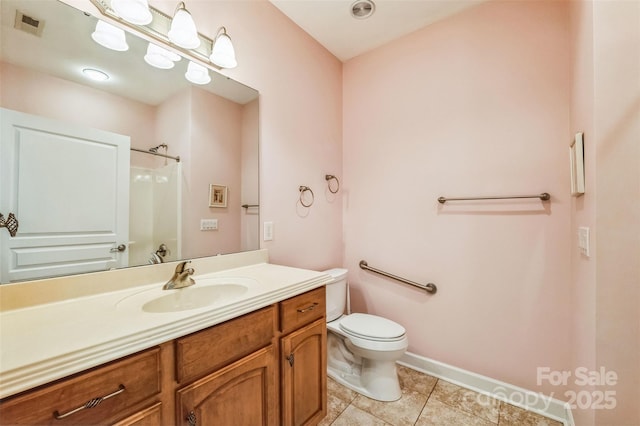 bathroom featuring tile patterned floors, vanity, toilet, and a shower