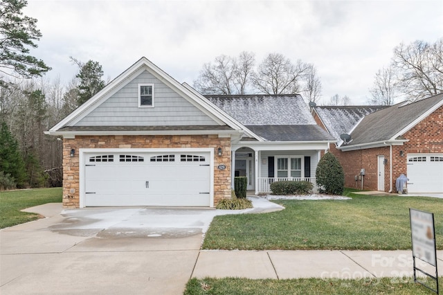 view of front of home featuring a porch, a garage, and a front yard