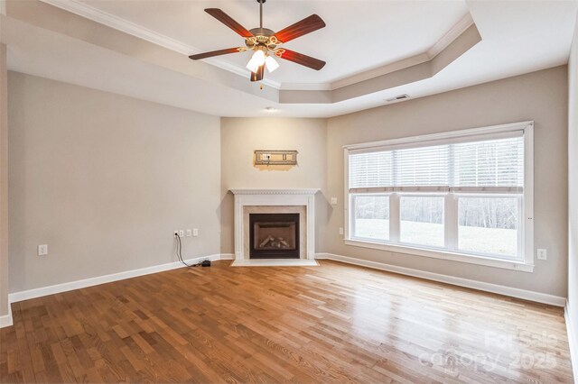 629 Cordova Ct, Salisbury, NC 28146 - unfurnished living room with crown molding, a tray ceiling, a fireplace with flush hearth, wood finished floors, and ceiling fan