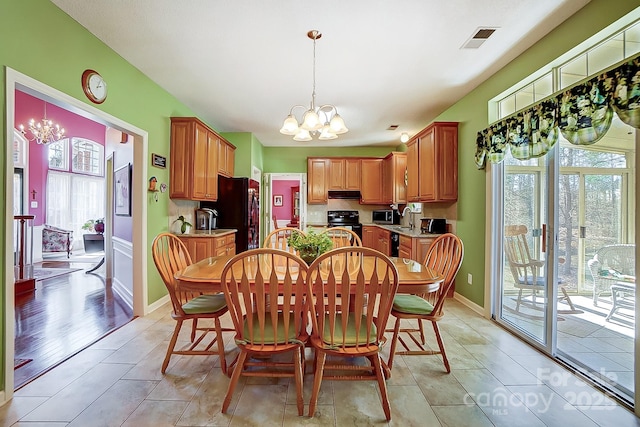 tiled dining room with a notable chandelier