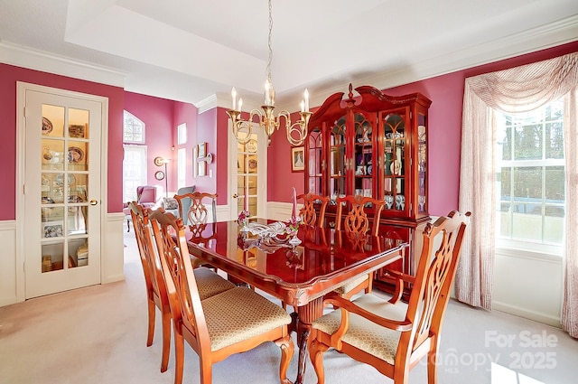 carpeted dining area with an inviting chandelier and crown molding