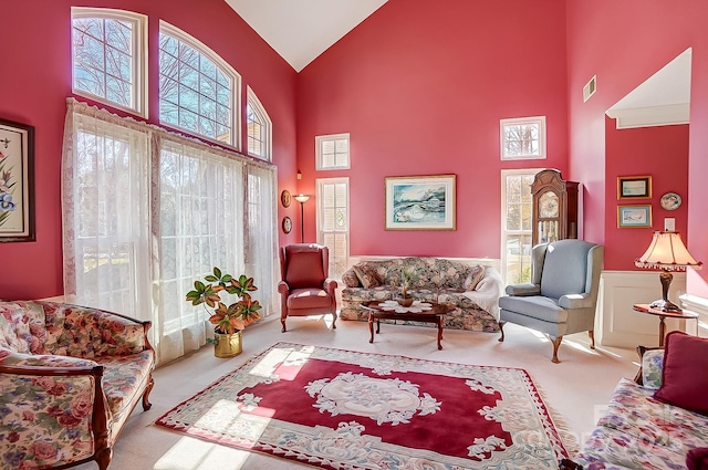 living room with carpet flooring and high vaulted ceiling