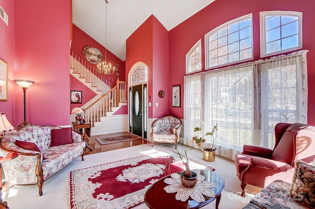 living room with a towering ceiling, carpet floors, and a chandelier