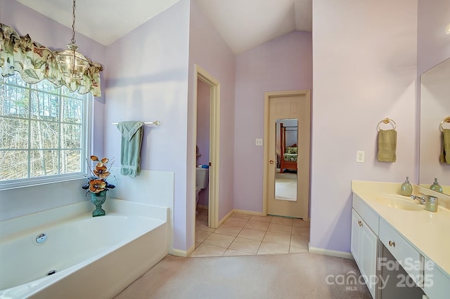 bathroom featuring tile patterned floors, lofted ceiling, toilet, vanity, and a washtub