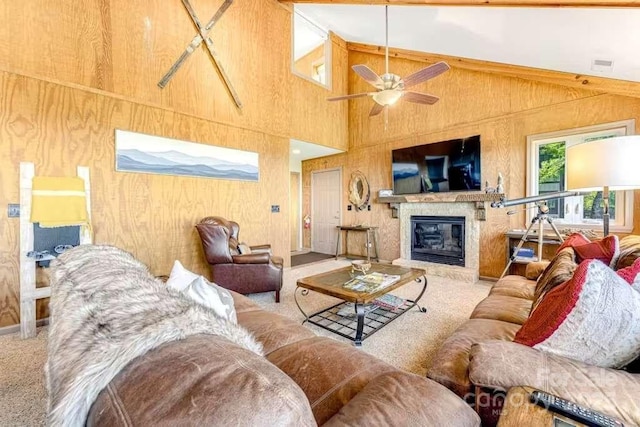 carpeted living room featuring high vaulted ceiling, wooden walls, and ceiling fan