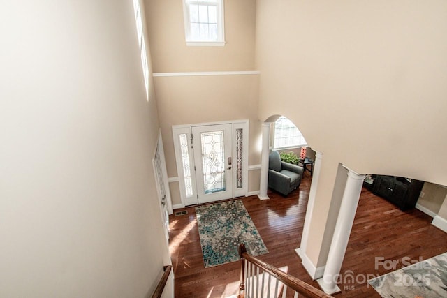 foyer entrance with a towering ceiling and dark hardwood / wood-style flooring