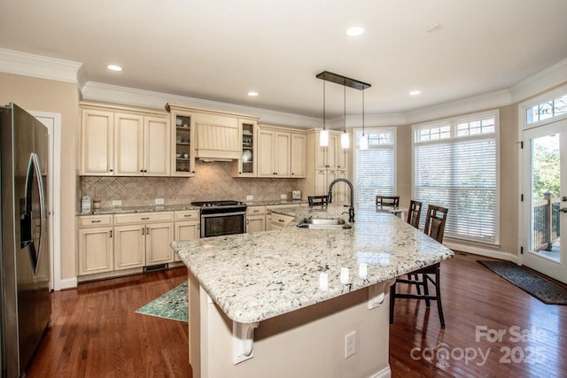 kitchen with decorative light fixtures, stainless steel appliances, a large island, a breakfast bar area, and sink