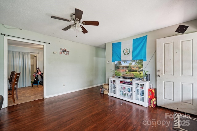 game room with ceiling fan, dark hardwood / wood-style flooring, and a textured ceiling