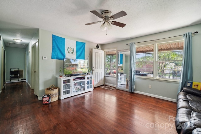 living room featuring ceiling fan, dark hardwood / wood-style floors, and a textured ceiling