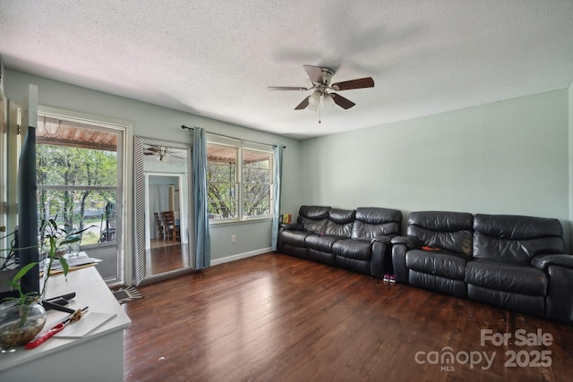 living room featuring ceiling fan, dark hardwood / wood-style flooring, and a textured ceiling