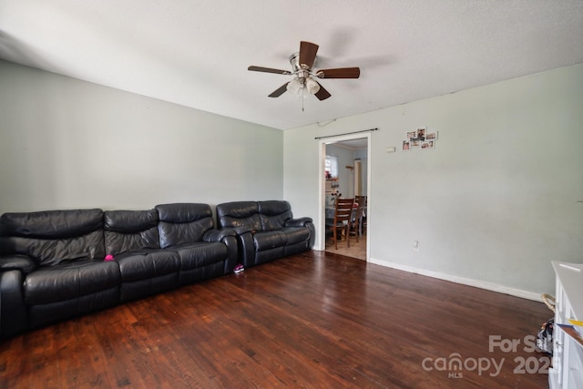 living room featuring ceiling fan and dark hardwood / wood-style flooring