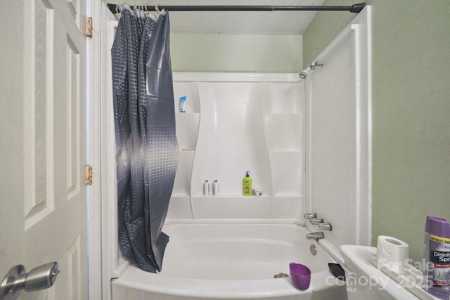 bathroom featuring shower / tub combo with curtain and a textured ceiling