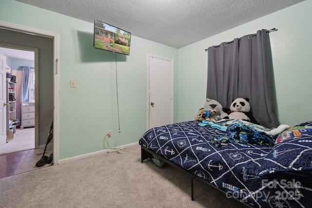 carpeted bedroom with a closet and a textured ceiling