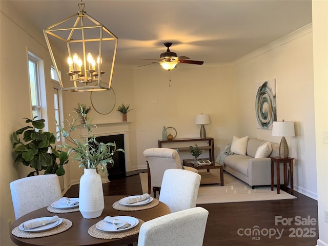 dining room with crown molding, ceiling fan with notable chandelier, and hardwood / wood-style floors