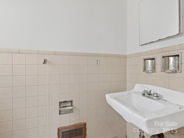 bathroom with tile walls and sink