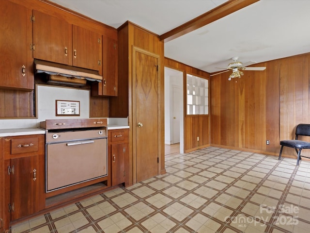 kitchen featuring ceiling fan and wood walls